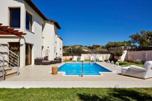 a swimming pool in a yard next to a house at Villa Vikla in Pissouri