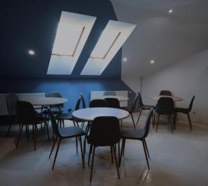 un grupo de mesas y sillas en una habitación en If Hostel en Leópolis