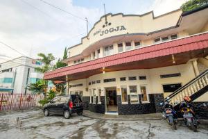 a building with two motorcycles parked in front of it at Hotel Jogja Bukittinggi in Bukittinggi