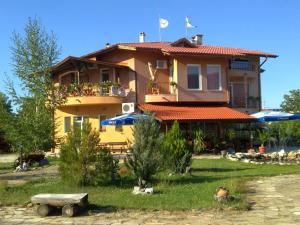 een geel huis met paraplu's ervoor bij Sveti Georgi Family Hotel in Varshets