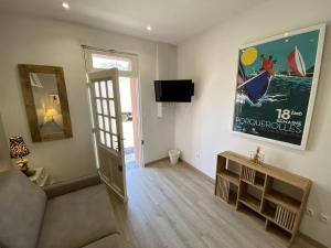 a living room with a couch and a flat screen tv at L'Arche de Porquerolles in Porquerolles