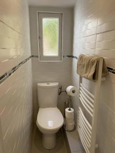 a white bathroom with a toilet and a window at L'Arche de Porquerolles in Porquerolles
