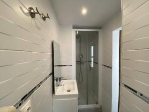 a white bathroom with a sink and a shower at L'Arche de Porquerolles in Porquerolles