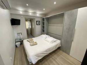a bedroom with a white bed with two towels on it at L'Arche de Porquerolles in Porquerolles