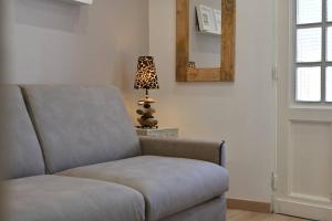 a chair in a room with a lamp and a mirror at L'Arche de Porquerolles in Porquerolles