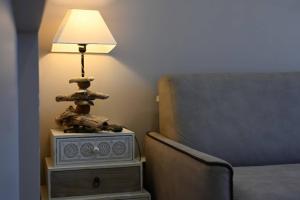 a lamp sitting on a table next to a bed at L'Arche de Porquerolles in Porquerolles