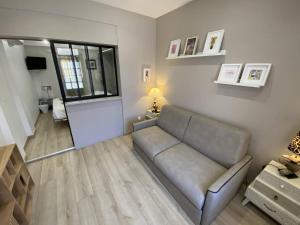 a living room with a couch and a window at L'Arche de Porquerolles in Porquerolles
