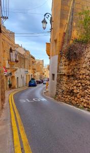 a street with a car parked on the side of the road at Just a Simple Room at Happy and Healthy Gozo in Victoria