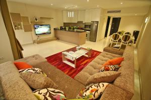 uma sala de estar com um sofá e uma cozinha em AlAshrafia Smart Residence no Cairo
