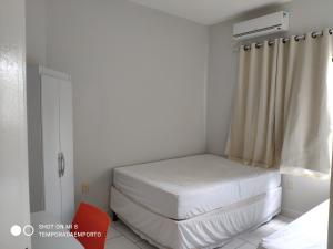 Habitación pequeña con cama y ventana en Apartamento Completo Porto Di Nassau, en Porto Seguro