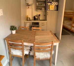 Boost Your Immo Vars Edelweiss 470 في فار: مطبخ مع طاولة وكراسي خشبية