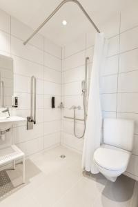 a white bathroom with a shower and a toilet at B&B HOTEL Basel in Basel