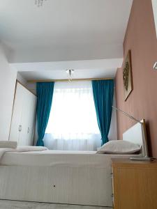 ママイアにあるAVA Apartmentsのベッドルーム1室(ベッド2台、青いカーテン付きの窓付)