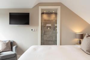 a bedroom with a white bed and a shower at Howe Top in Bowness-on-Windermere