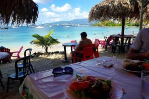 a table with plates of food on a beach at Loue maison en Martinique in Le Vauclin