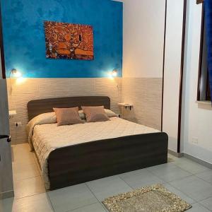 ein Schlafzimmer mit einem großen Bett in einem Zimmer in der Unterkunft Bilocale Blu - A casa di Ludovica e Martina in Gallipoli