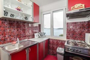 cocina roja con fregadero y fogones en Apartment Giovani, en Slano