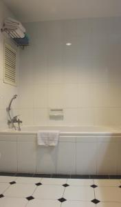 a white bathroom with a tub and a sink at Lotus House in Jomtien Beach