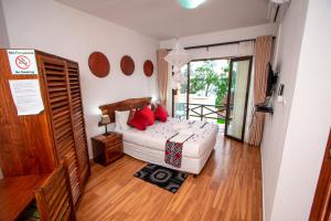una camera da letto con un letto con cuscini rossi di Villa Espanhola Bilene a Vila Praia Do Bilene