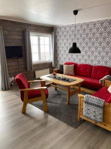 a living room with a red couch and a table at Oppdal Alpintun in Oppdal