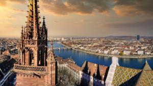 a tall building next to a river with a city at B&B HOTEL Basel in Basel