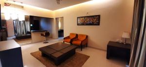 sala de estar con silla y mesa en Leisure Stays - Premium Suites, en Chennai