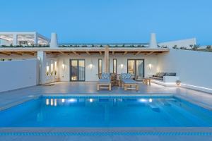 una villa con piscina di notte di La Grande Vue-Private hilltop villas with private pools a Vívlos
