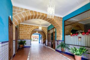 un pasillo de un edificio con un arco en Hostal El Caballo Blanco, en Osuna