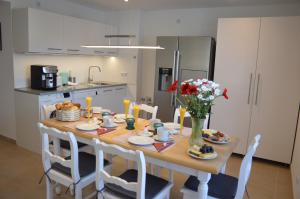 a kitchen with a table with food and flowers on it at Arber Lofts in Bayerisch Eisenstein