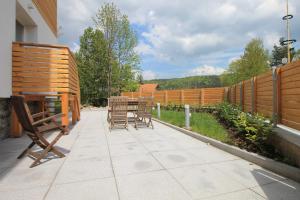 a patio with chairs and a table and a fence at Arber Lofts in Bayerisch Eisenstein