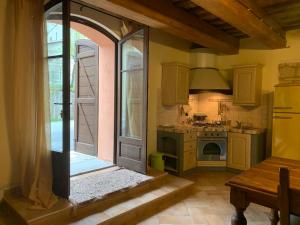 a kitchen with an archway and an open door at Casa del Borgo in Cantiano