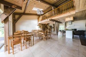 una sala da pranzo con tavoli e sedie in legno di Guest House "Stellas" a Ziemupe
