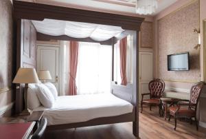 a bedroom with a canopy bed with a window at Hotel Fidder - Patrick's Whisky Bar in Zwolle