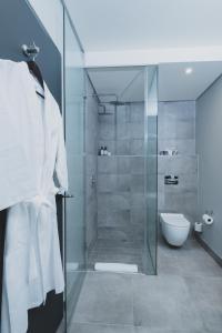 a bathroom with a glass shower with a toilet at The Catalyst Apartment Hotel by NEWMARK in Johannesburg +135 photos