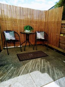 two chairs and a table in front of a fence at NORTH SHORE HOMESTAY Auckland in Auckland