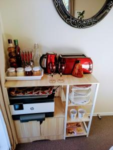 a room with a table with wine glasses and a mirror at NORTH SHORE HOMESTAY Auckland in Auckland