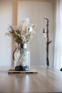 um vaso de vidro com flores sobre uma mesa em LE TRESUM - Appartement + Garage - V-RENT em Annecy