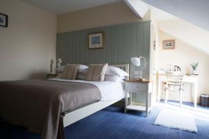 um quarto com uma cama e uma mesa com uma cadeira em Seacroft em Holyhead
