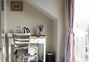 a kitchen with a desk with a chair and a window at Seacroft in Holyhead