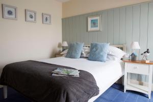a bedroom with a large white bed with blue pillows at Seacroft in Holyhead