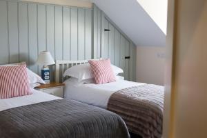 a bedroom with two beds and a stairway at Seacroft in Holyhead