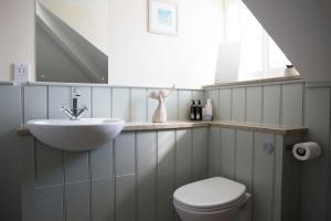 a bathroom with a sink and a toilet and a window at Seacroft in Holyhead