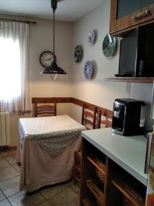 a kitchen with a table and a microwave at apartamento lahuerta in Bronchales