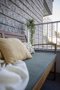 uma cama sentada numa varanda com uma parede de tijolos em LE TRESUM - Appartement + Garage - V-RENT em Annecy