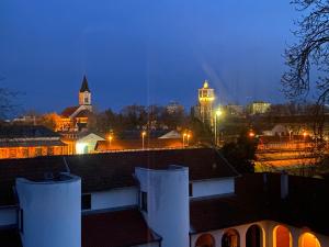 una vista de la ciudad por la noche con una iglesia en Gosztonyi Villa, en Siófok