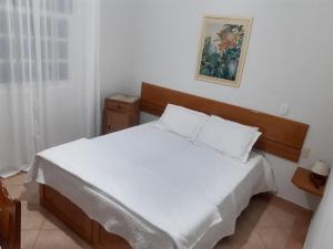 une chambre avec un grand lit avec des draps blancs dans l'établissement Pousada Paradiso, à Santa Teresa