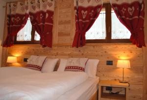 a bedroom with a bed with red curtains at Fohre1748 in Gressoney-la-Trinité