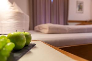 2 pommes vertes assises sur une table dans une chambre d'hôtel dans l'établissement Landhaus Menz, à Oberstdorf