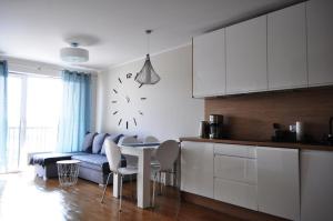 uma cozinha com um sofá e uma mesa num quarto em Apartament , Bałtycka 11 em Kolobrzeg