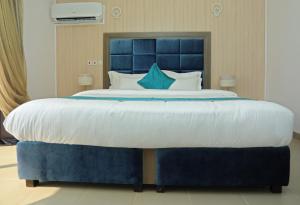 ラゴスにあるRiviera Suitesのベッドルームに大型ベッド1台(青いヘッドボード付)